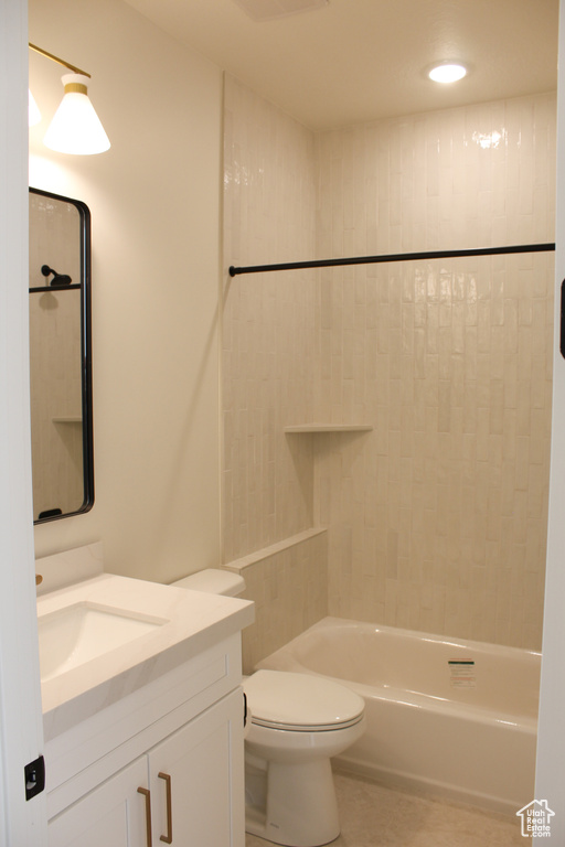 Full bathroom featuring vanity, toilet, and tiled shower / bath combo