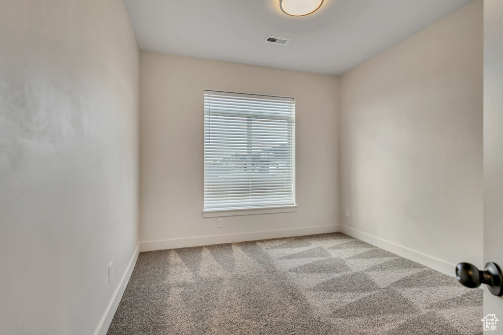 Carpeted spare room with baseboards