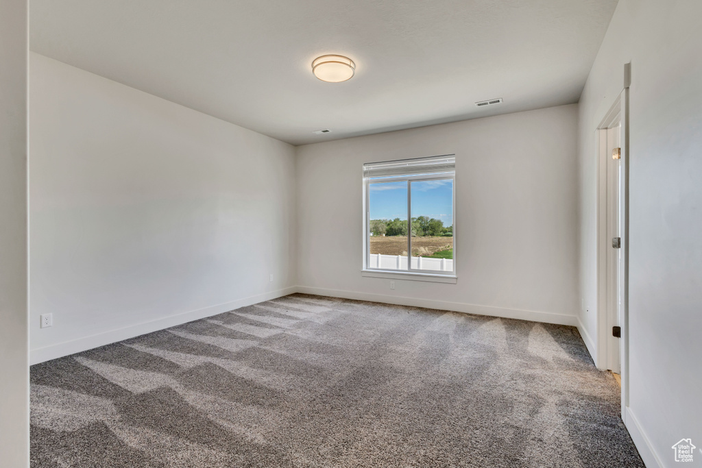 Spare room featuring carpet floors and baseboards