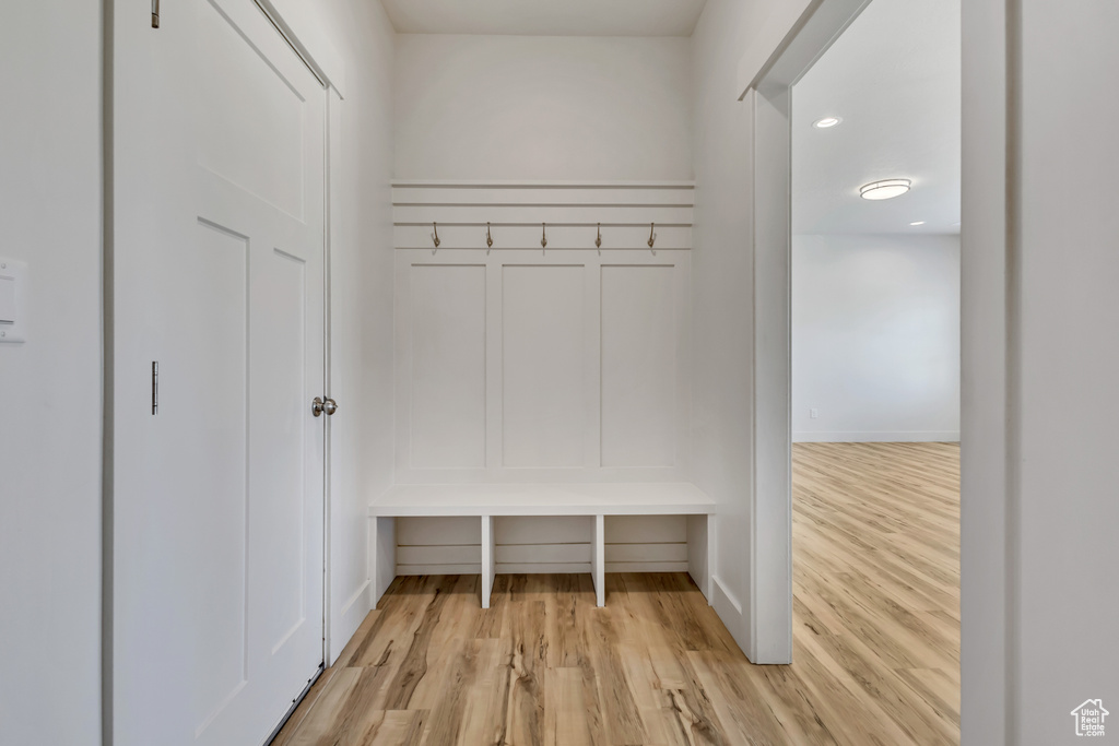 Mudroom featuring light wood finished floors and baseboards