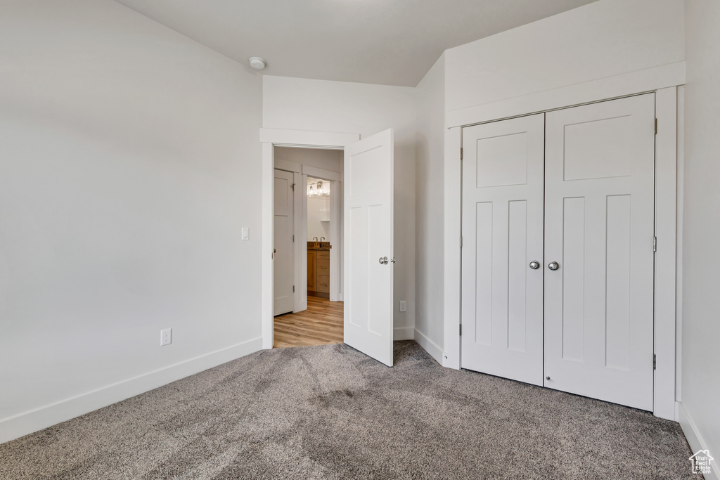 Unfurnished bedroom featuring carpet flooring, baseboards, and a closet