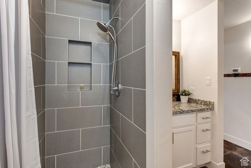 Bathroom featuring a shower with curtain and vanity