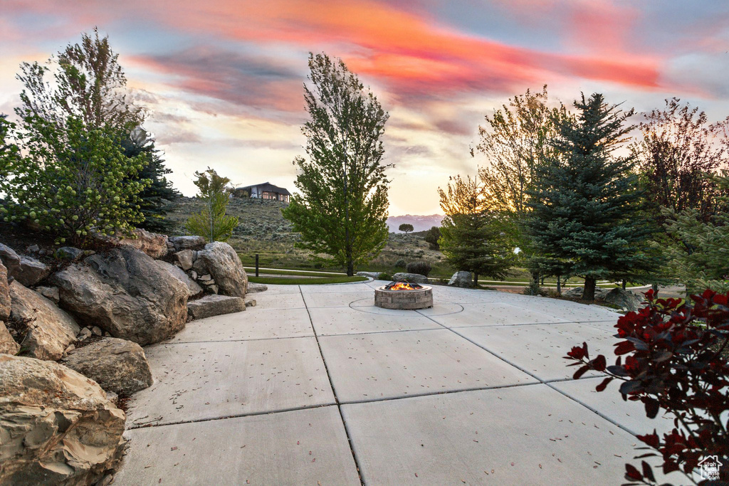 Patio terrace at dusk featuring an outdoor fire pit and a patio