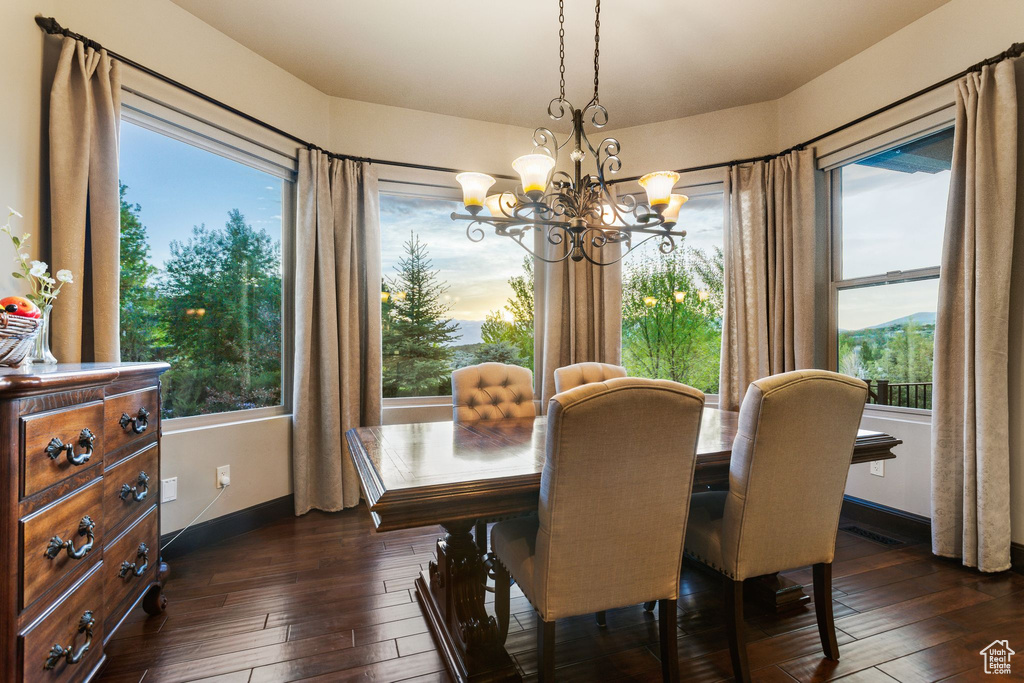 Dining area featuring a chandelier, dark wood-type flooring, and baseboards