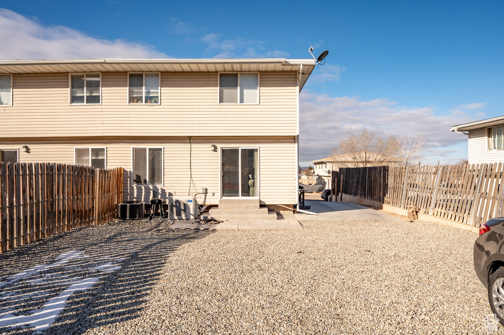 Back of house with cooling unit and a patio