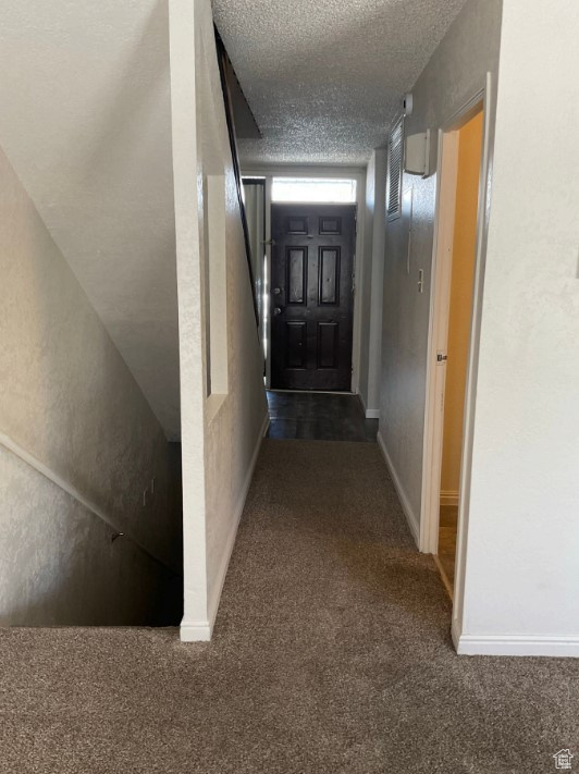 Corridor featuring carpet and a textured ceiling