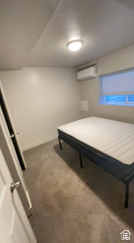 Bedroom with carpet flooring and a wall unit AC