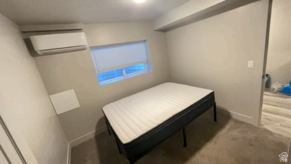 Bedroom featuring carpet floors and a wall mounted AC