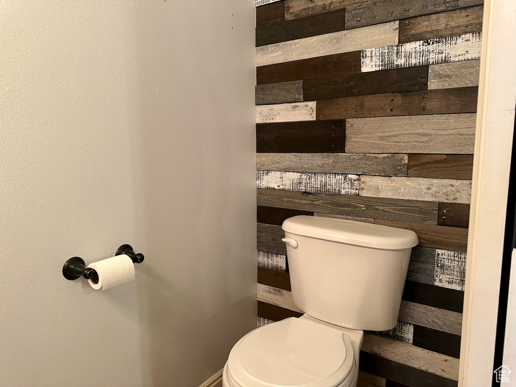 Bathroom featuring wooden walls and toilet