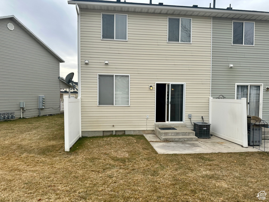 Back of property with a yard, a patio, and central air condition unit