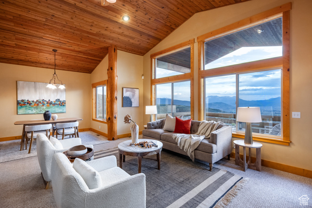 Living area with carpet, vaulted ceiling, wooden ceiling, a mountain view, and a chandelier