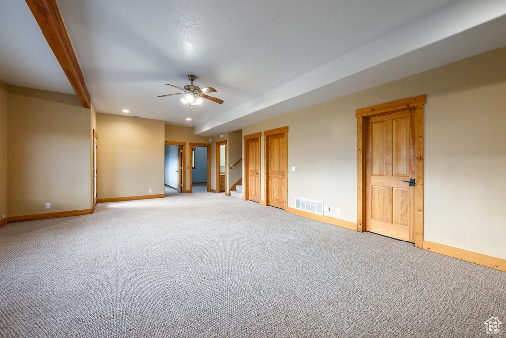 Carpeted empty room with a ceiling fan, recessed lighting, and stairway