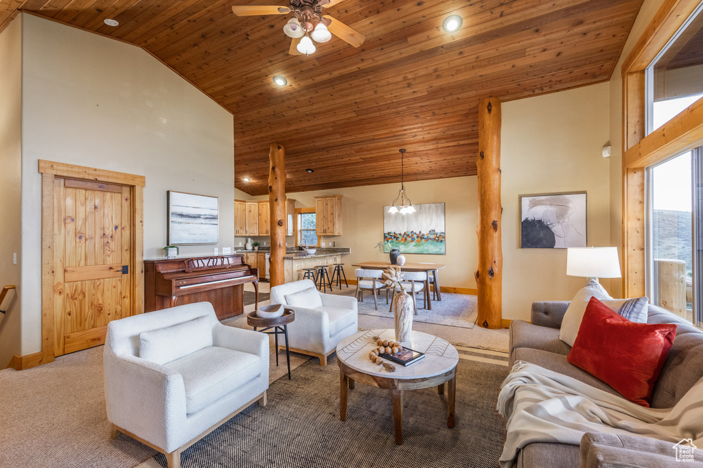 Living room with wooden ceiling, ceiling fan, light colored carpet, high vaulted ceiling, and a chandelier