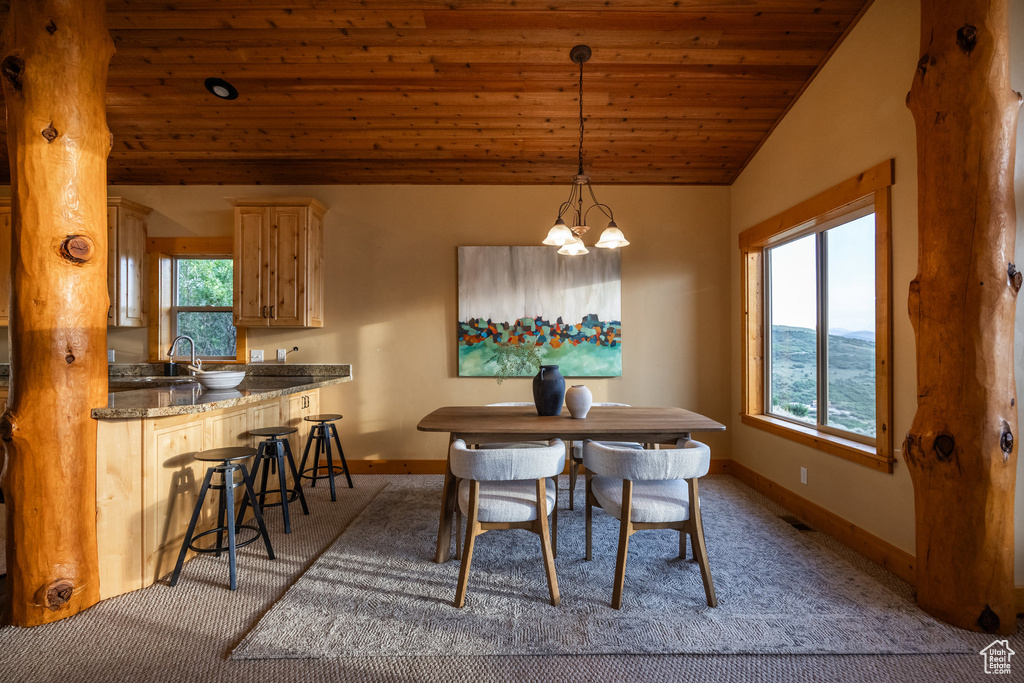 Dining room with wooden ceiling, light carpet, a chandelier, and vaulted ceiling