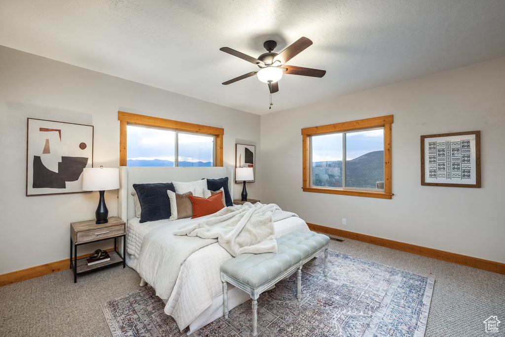 Carpeted bedroom with baseboards and ceiling fan