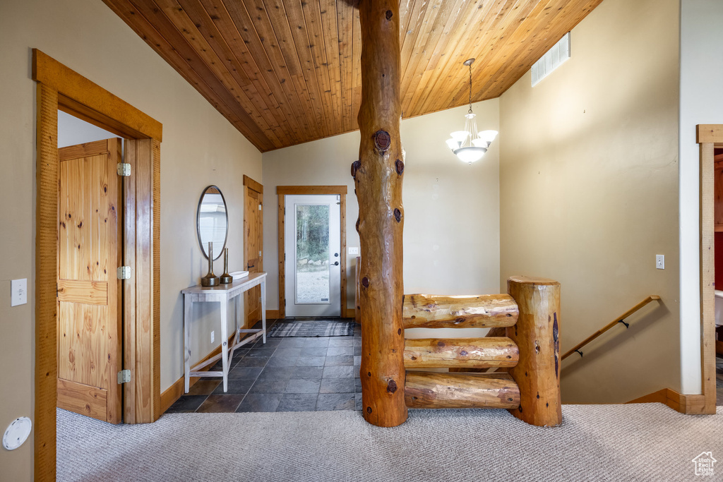Carpeted foyer entrance with vaulted ceiling, wood ceiling, and a chandelier