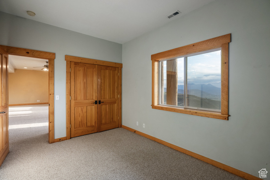 Unfurnished bedroom featuring light colored carpet and baseboards