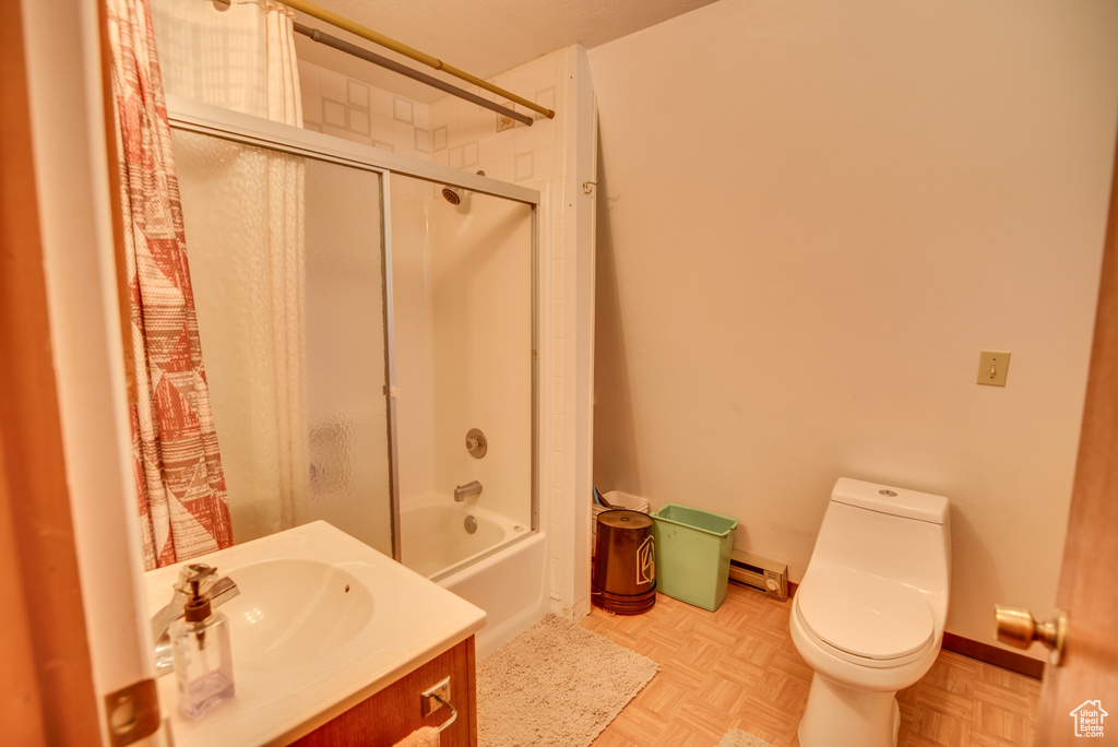Full bathroom with vanity, parquet floors, shower / bath combination with glass door, and toilet