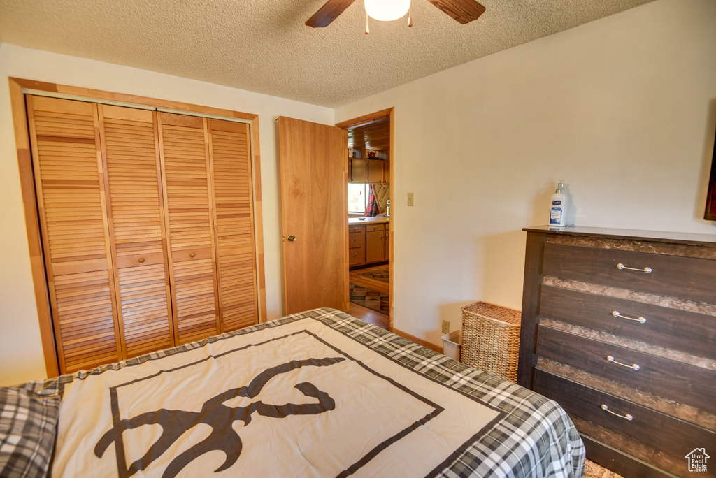 Bedroom featuring ceiling fan, a textured ceiling, and a closet