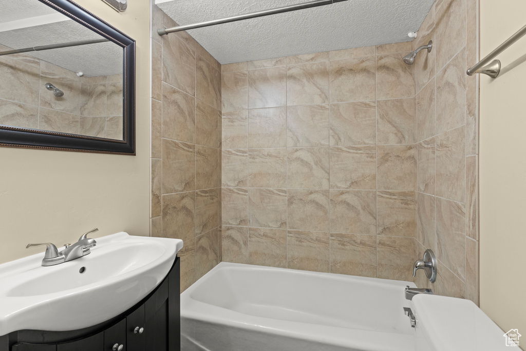 Bathroom with shower / washtub combination, vanity, a textured ceiling, and toilet