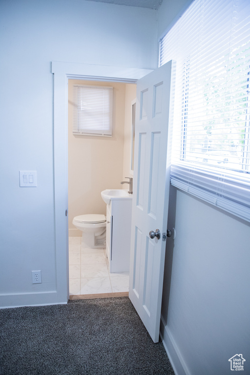 Bathroom featuring plenty of natural light, baseboards, toilet, and vanity