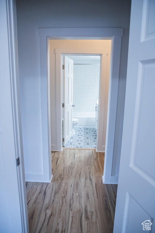 Hallway featuring wood finished floors and baseboards
