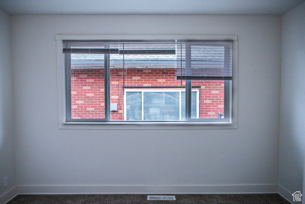 Unfurnished room with baseboards and carpet