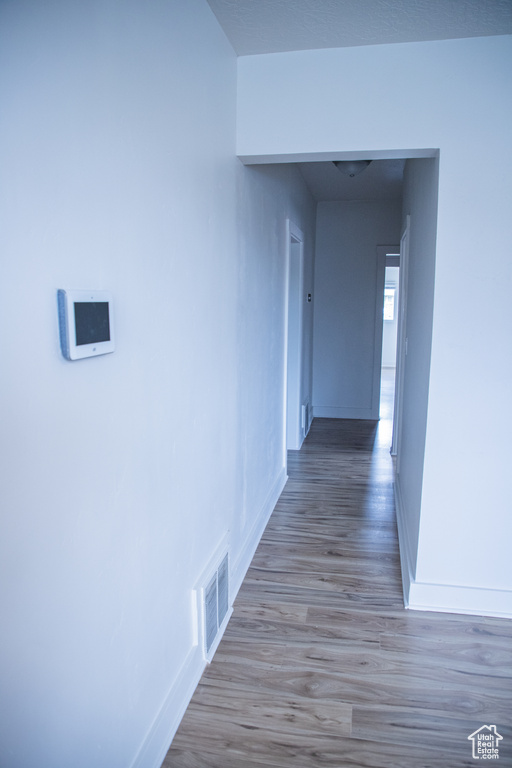 Corridor with baseboards and wood finished floors
