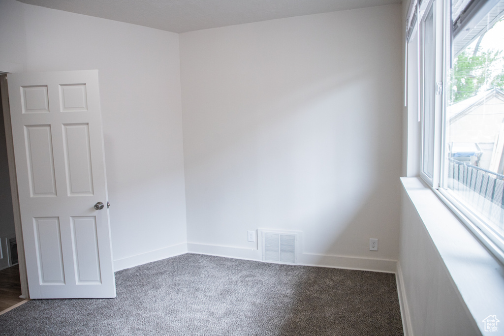 Carpeted spare room with baseboards