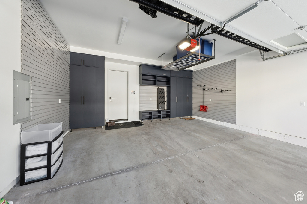 Garage featuring a garage door opener and electric panel