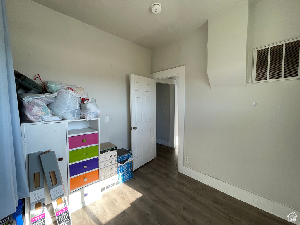 Bedroom featuring dark wood-style flooring and baseboards