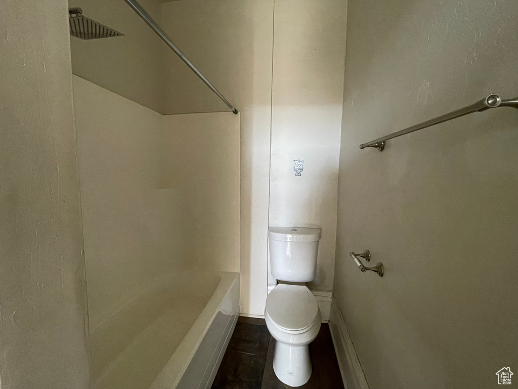 Bathroom with toilet, tile patterned flooring, baseboards, and shower / bath combination