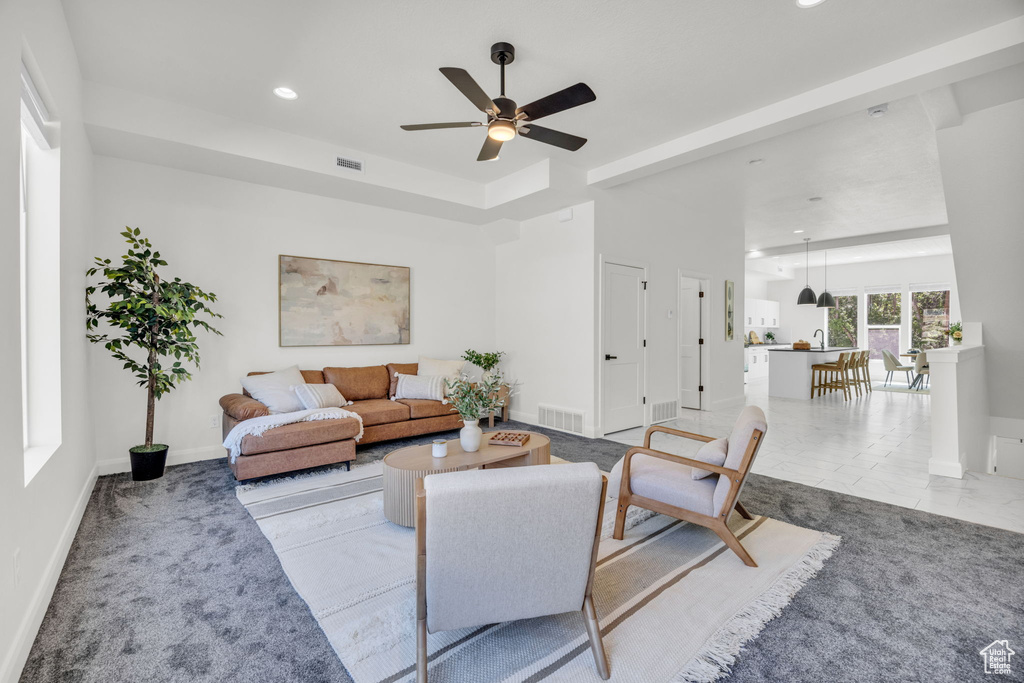 Carpeted living room with ceiling fan