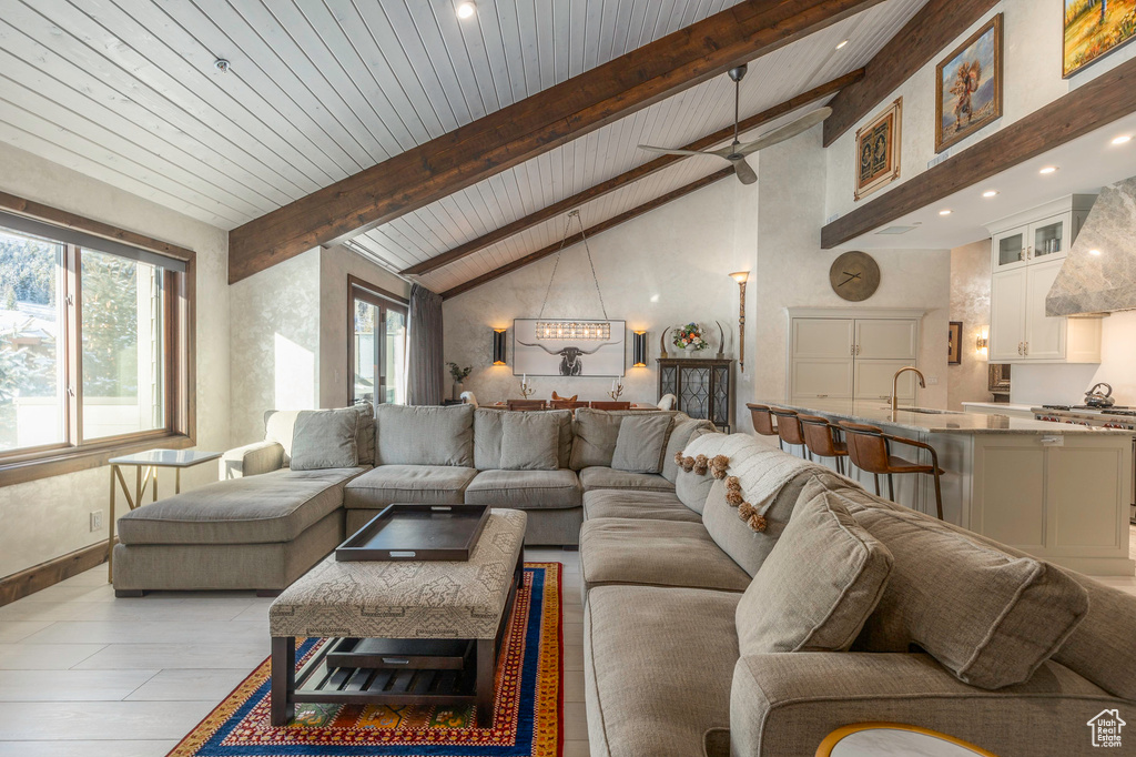 Living room with wood ceiling with exposed beams, recessed lighting, high vaulted ceiling, and a ceiling fan