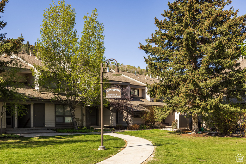 View of front of house with a front yard and roof with shingles