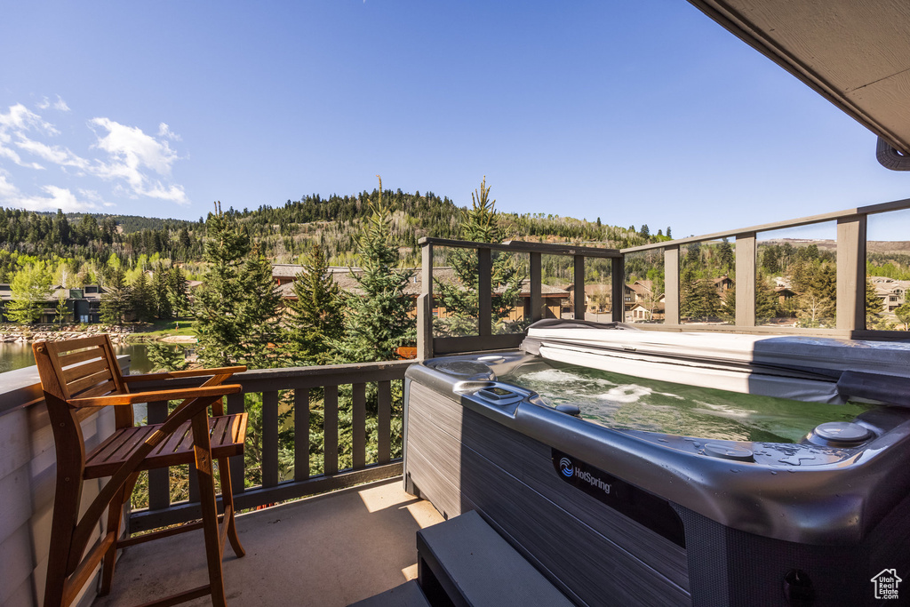 View of patio / terrace with a forest view and a hot tub