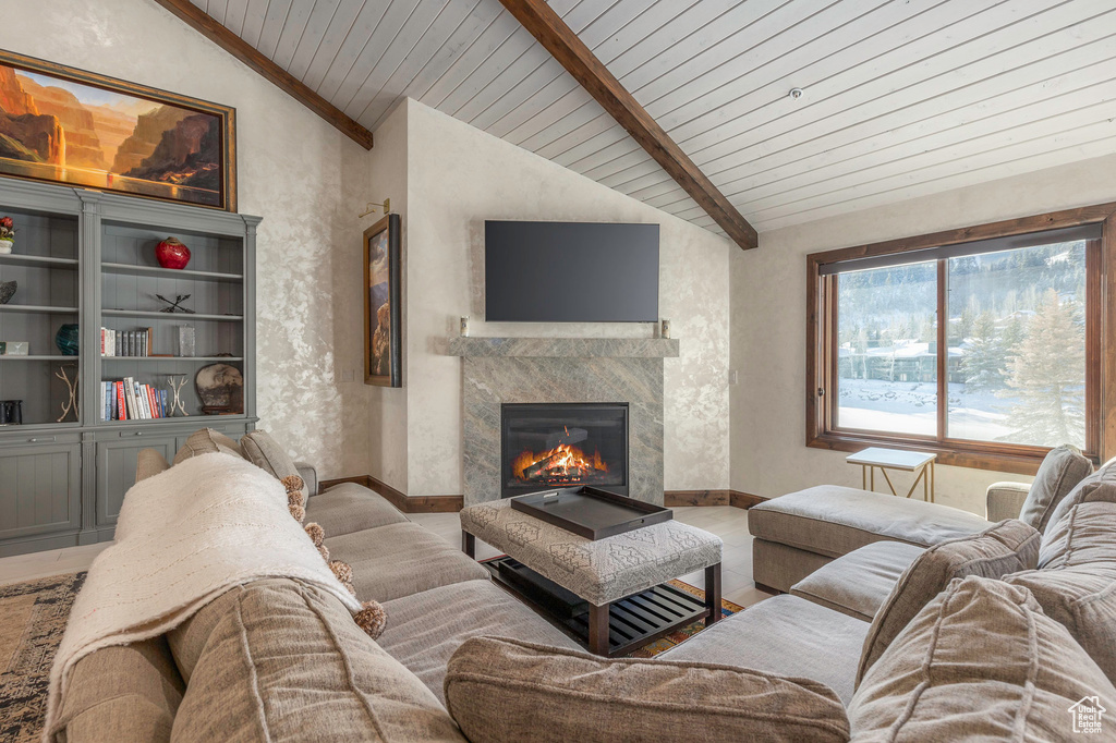 Living room with a fireplace, wood ceiling, and baseboards
