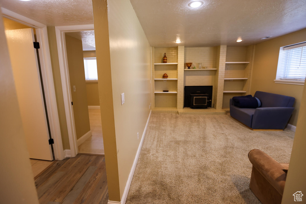 Living room featuring built in shelves, plenty of natural light, and a textured ceiling