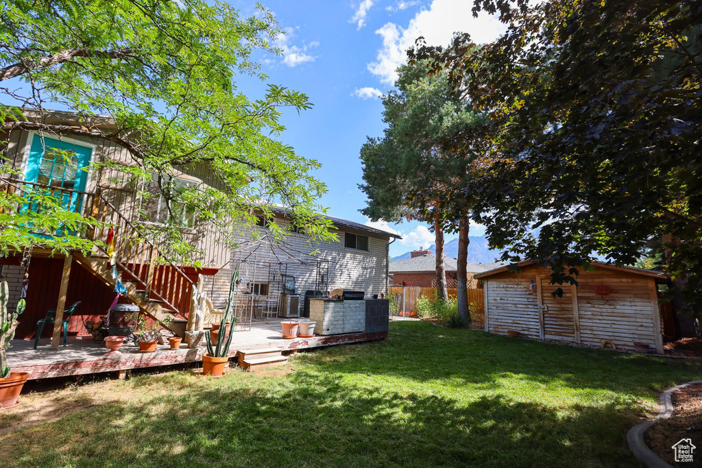 View of yard featuring a wooden deck and an outdoor structure