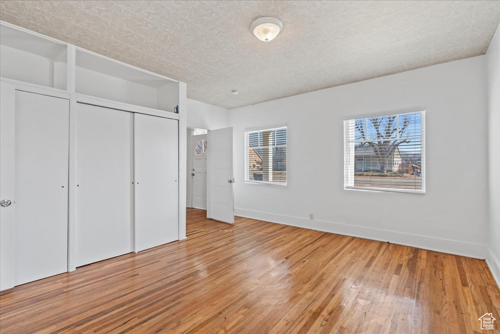 Unfurnished bedroom with hardwood / wood-style floors and a closet