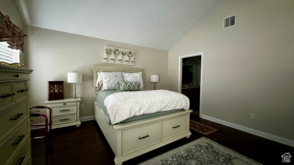 Bedroom with vaulted ceiling and dark wood-type flooring