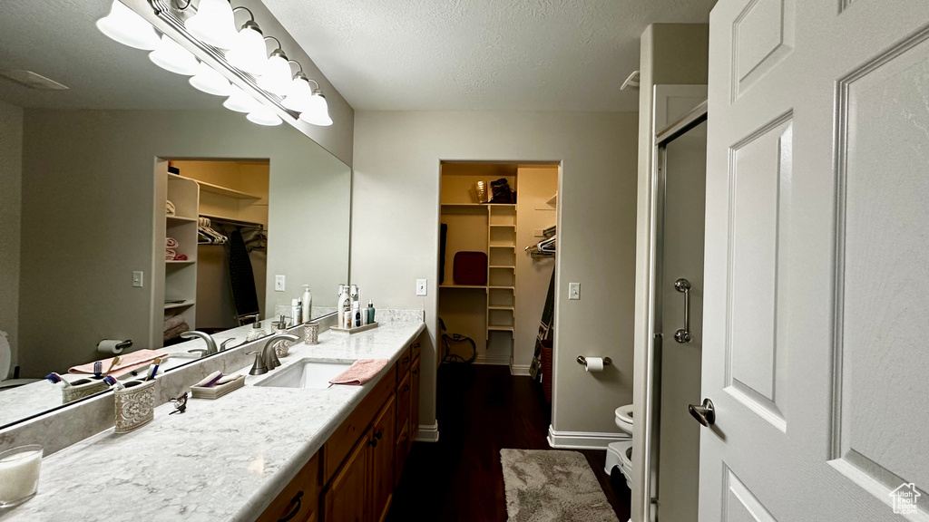 Bathroom featuring vanity, toilet, and a shower with shower door