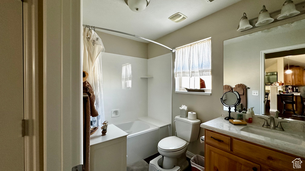 Full bathroom with vanity, shower / tub combo, and toilet