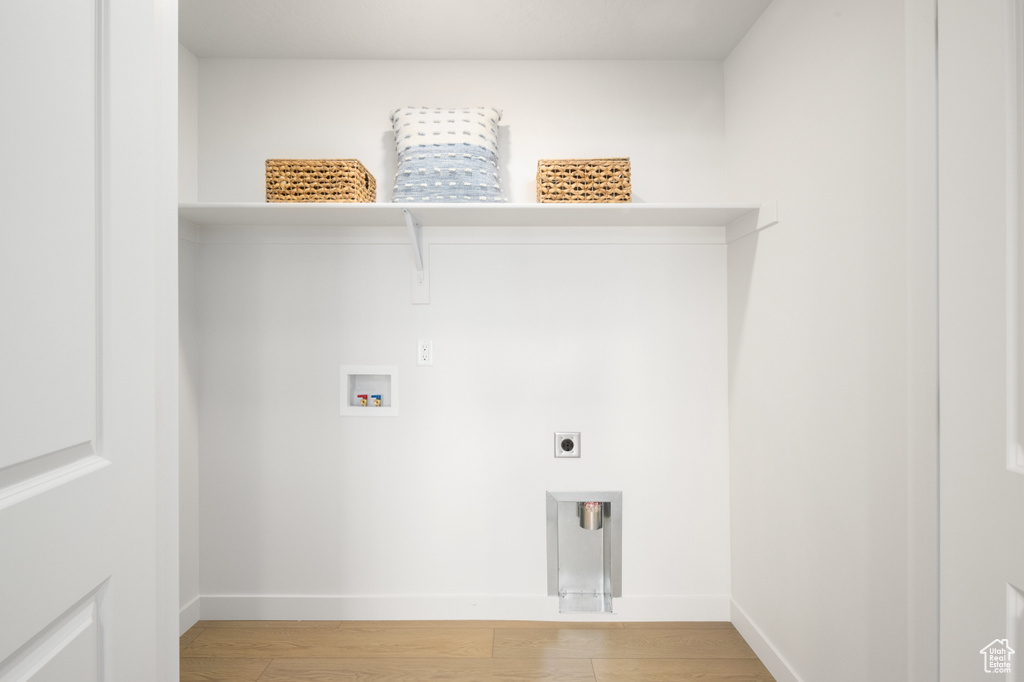 Clothes washing area featuring hardwood / wood-style floors, hookup for a washing machine, and hookup for an electric dryer