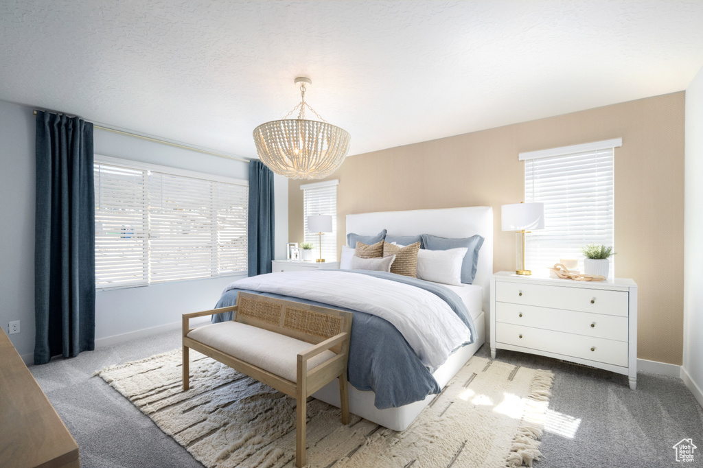 Bedroom with light carpet and an inviting chandelier