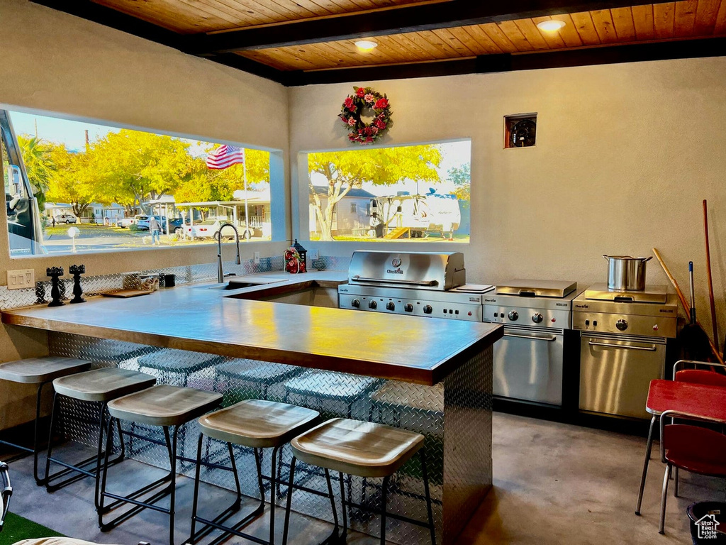View of patio featuring a grill, an outdoor kitchen, and an outdoor wet bar