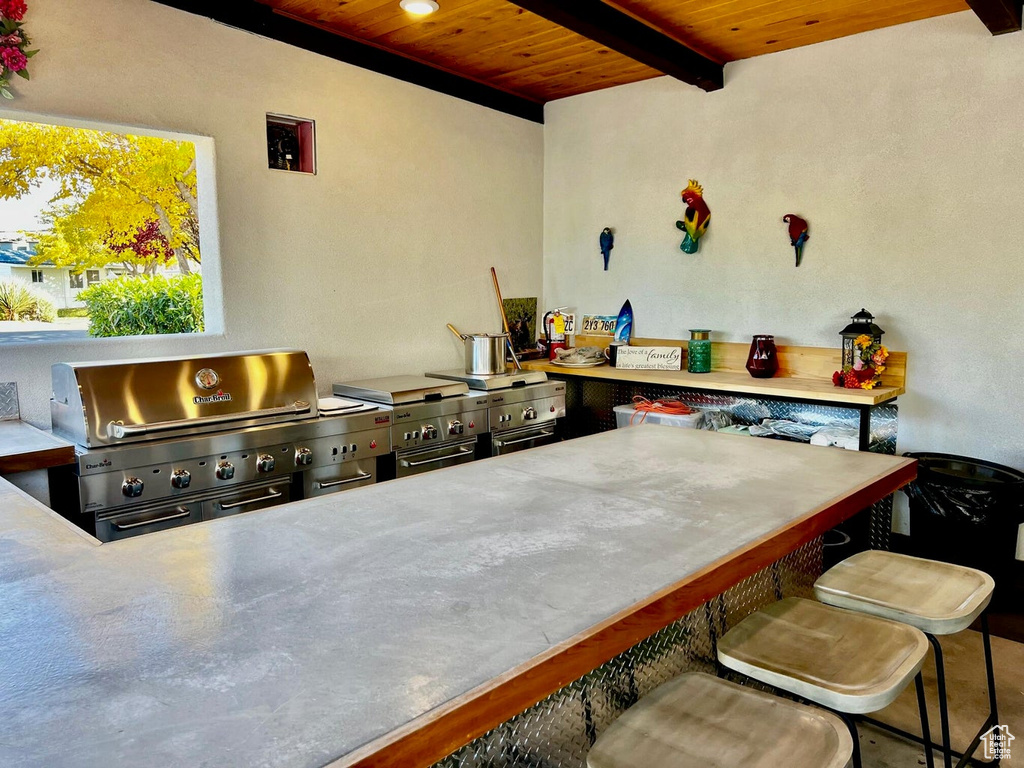 Kitchen with wood ceiling, a kitchen breakfast bar, and beam ceiling
