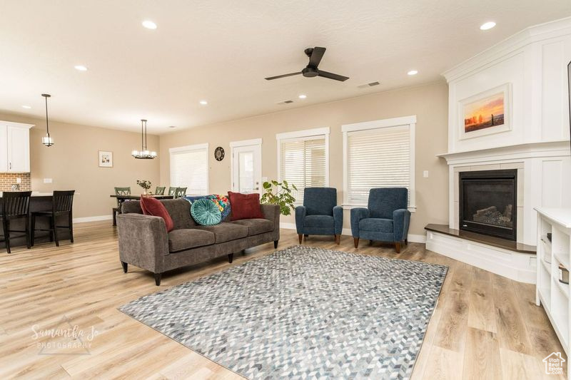 Living room with ceiling fan and light wood-type flooring