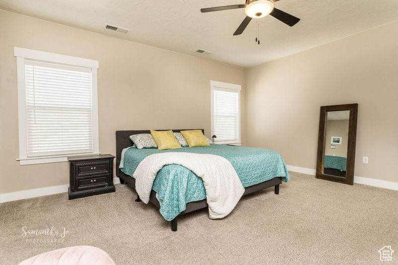 Carpeted bedroom with ceiling fan