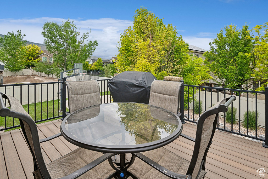 Wooden terrace with outdoor dining space and a grill